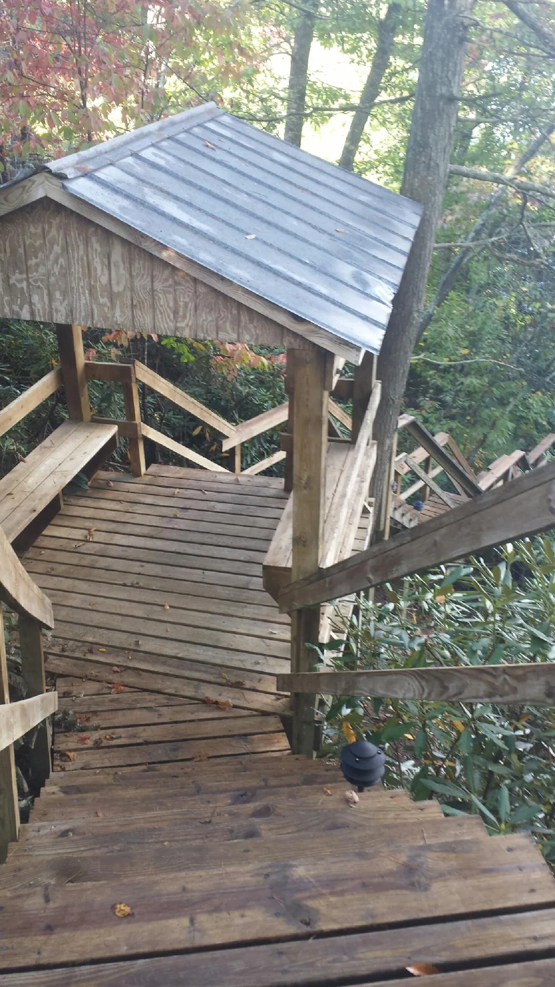 Metal roofed shelter over wooden steps on a wooded walkway — Skylight Repair & Installation work by our crew in Klamath Falls