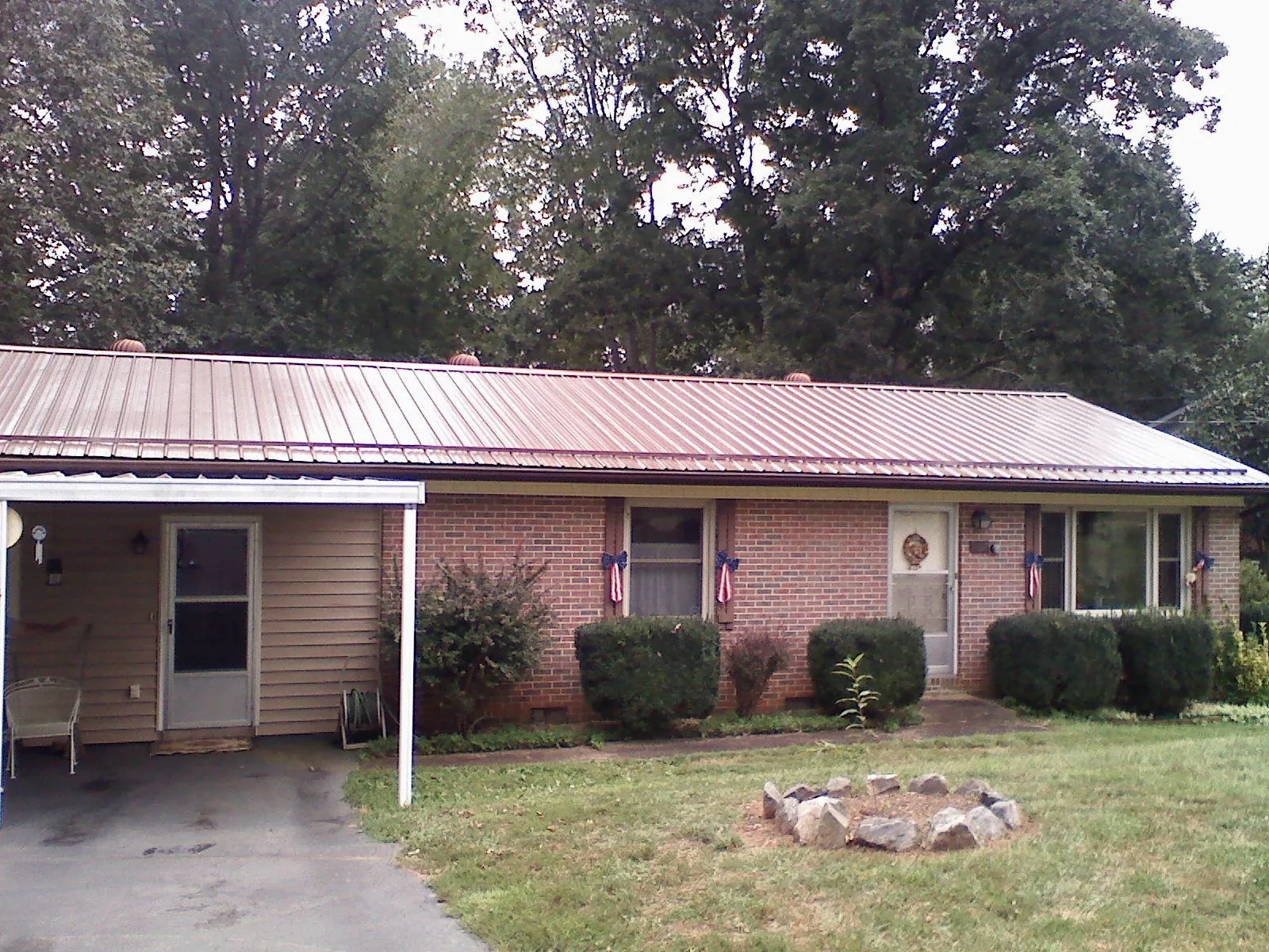 Bronze metal roof and carport on a brick ranch home — Roof Repair work by our crew in Klamath Falls
