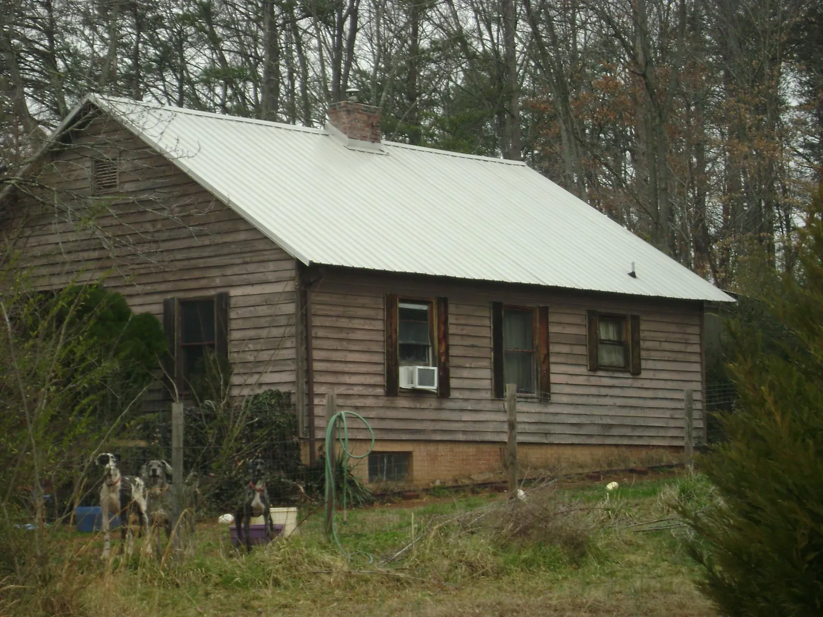 White metal roof on an old wood sided farmhouse, from a Metal Roof Installation job in Klamath Falls